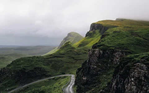Winding road through green highland hills