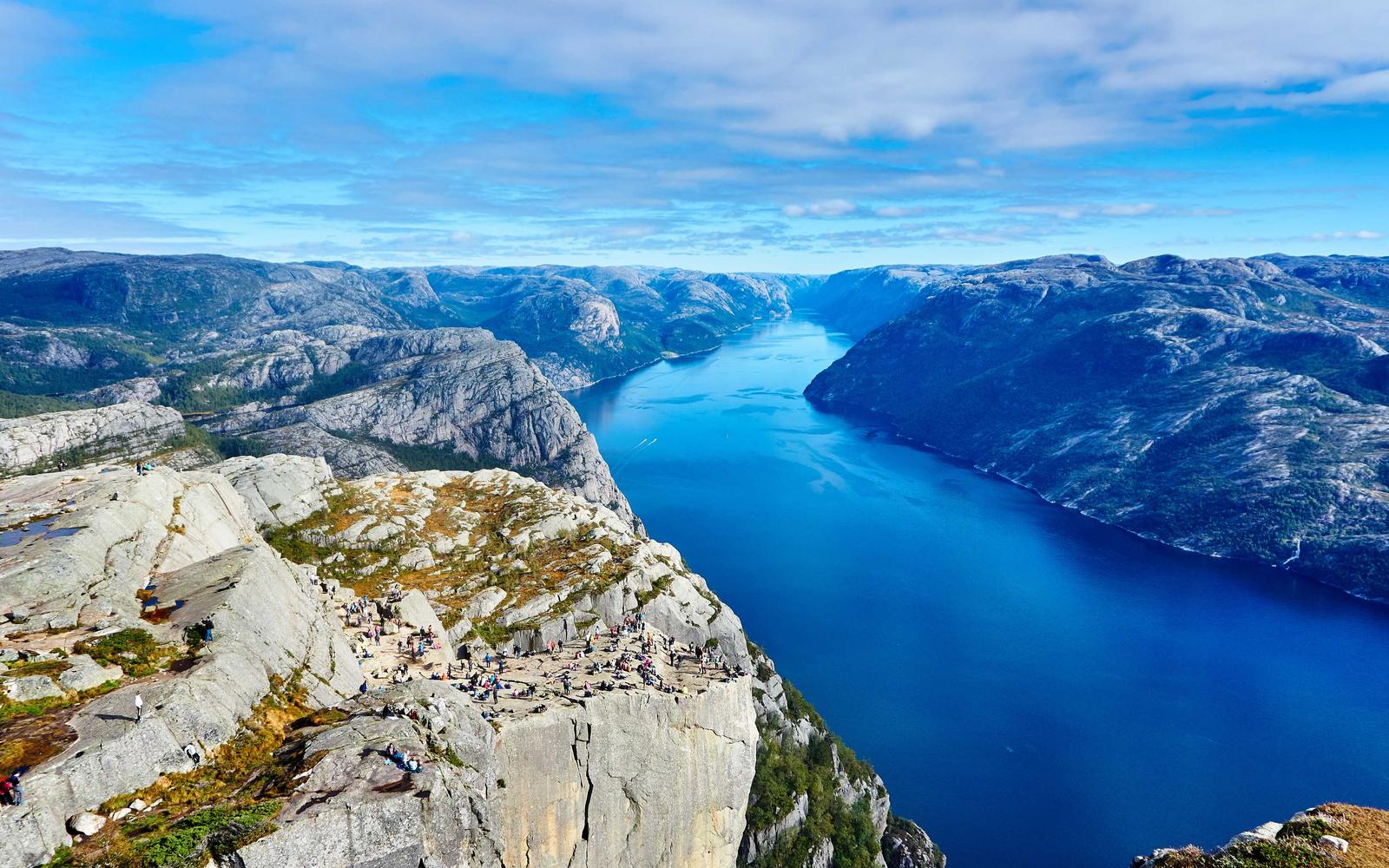 Fjord seen from a rocky plateau under a blue sky