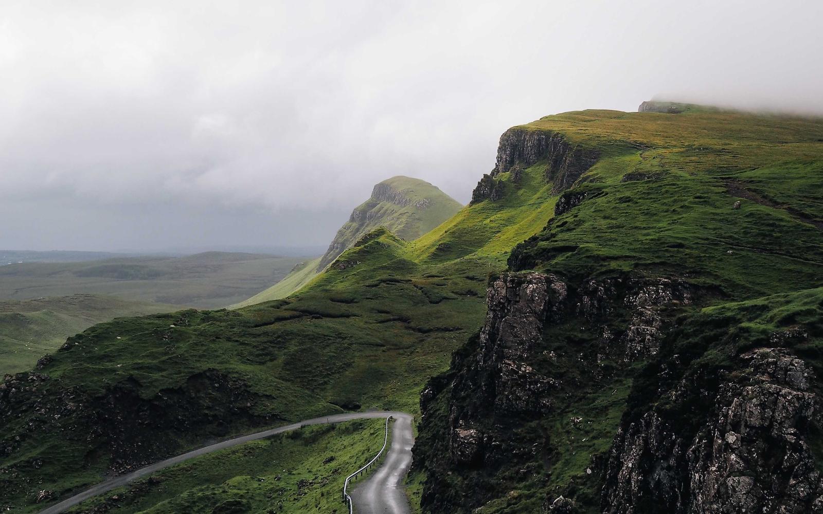 Winding road through green highland hills